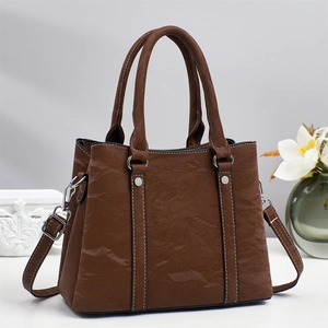 Brown textured tote bag with white contrast stitching and adjustable shoulder strap