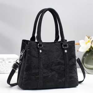 Fashionable black faux leather handbag with marble texture and adjustable shoulder strap