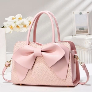 Pink woven leather handbag with a large bow detail and adjustable shoulder strap