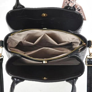 Detail view of large capacity black tote bag showing three interior compartments and lining