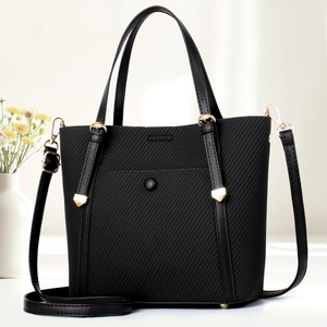 Elegant black twill crossbody tote bag with golden hardware and adjustable strap