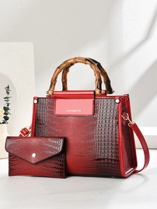 Detail of red and black gradient handbag set with bamboo handle and crocodile texture
