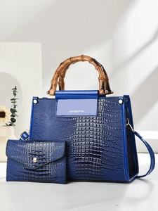 Close-up of blue faux-crocodile leather bag with vintage bamboo handles and matching clutch