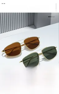 Detail of two metal pilot sunglasses with brown and green lenses on white stands