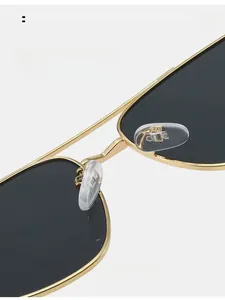 Close-up of comfortable silicone nose pads and golden metal frame on square sunglasses
