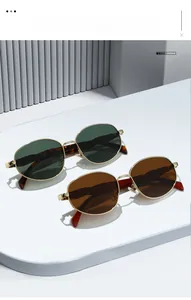 Classic gold metal round sunglasses in green and brown lenses on a white display