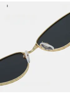 Detail of vintage gold metal bridge with engraved texture and soft silicone nose pads
