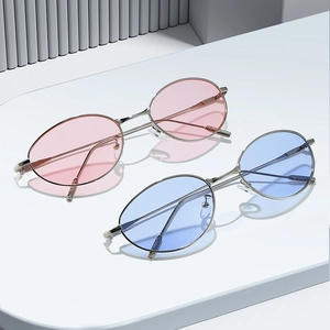 Lunettes de soleil ovales rétro avec monture en métal rose et bleu clair sur présentoir