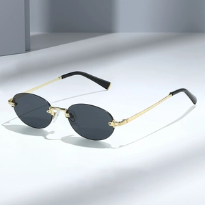 Retro frameless oval sunglasses with dark lenses and gold metal temples in studio lighting