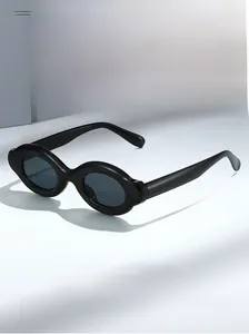 Detail shot of vintage black oval sunglasses with thick frames and dark grey lenses