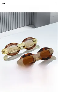 Close-up of retro oval sunglasses in tortoise and amber textures on a white stand