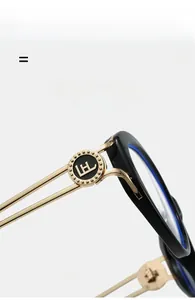 Detail of black acetate frames with dual gold metal temples and round logo hinge