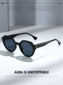 Detail of minimalist black sunglasses with deep blue lenses and gold metal accents