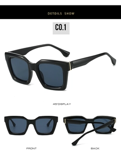 Detail view of black square sunglasses with dark lenses and gold metal accents