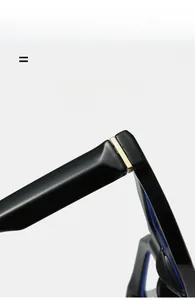 Detail view of high-quality black glasses frame hinge with golden metal accents
