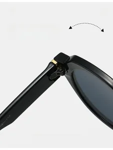 Detailed view of durable golden metal reinforced hinges on black acetate sunglasses