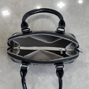 Top view of spacious interior with herringbone lining and pockets in black embossed bag