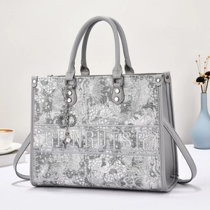 Detail of grey embroidery tote bag with heart charm and pearl decoration