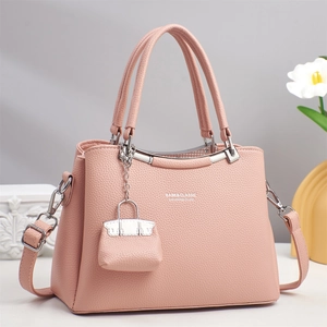 Detail der rosa Handtasche aus Leder mit Logo-Druck und Mini-Taschenanhänger