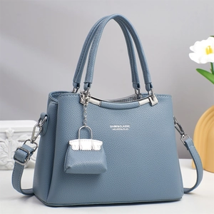 Detail der nebelblauen Ledertasche mit Narbenleder, Silberbeschlägen und Anhänger