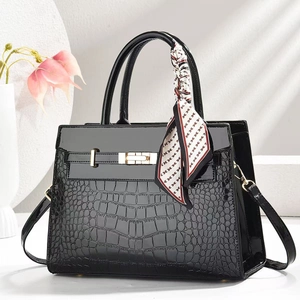 Elegante borsa a mano nera con goffratura coccodrillo lucida e foulard di seta decorativo