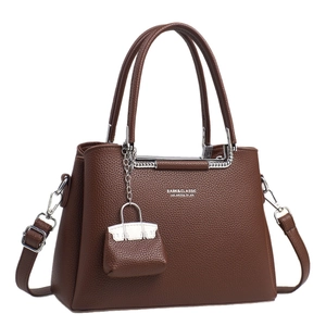 Brown lychee leather crossbody handbag with silver hardware and mini charm