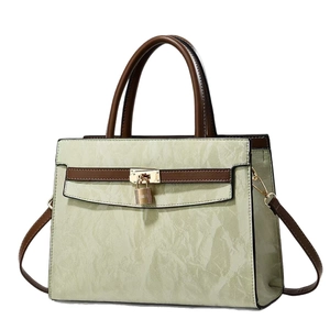 Light green textured women's tote bag with brown handles and gold padlock detail