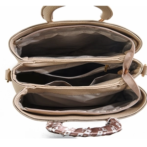 Detailed interior view of a beige leather tote bag with multiple compartments and a silk scarf