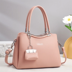 Pink lychee texture handbag with mini pouch pendant and floral background detail