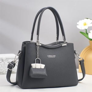 Detailed macro view of dark grey lychee textured leather handbag with silver metal hardware