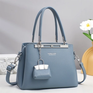 Close-up of fog blue lychee pattern leather handbag with silver hardware and small charm