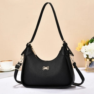 Minimalist black textured leather underarm bag with gold hardware and bow detail