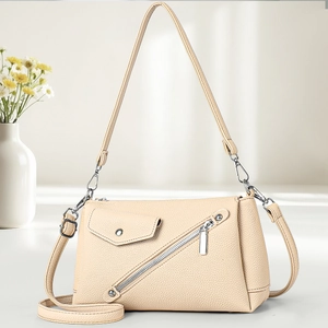 Minimalist beige crossbody hobo bag with diagonal zipper and faux leather texture