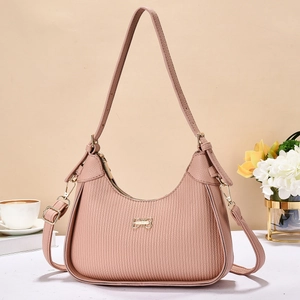 Detail of nude pink pleated leather handbag with golden bow buckle and fashion hardware
