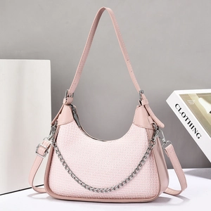 Detail of pink shoulder bag with monogram texture and silver metal chain strap