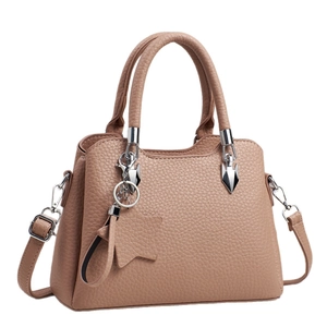 Beige faux leather tote bag with star charm and silver hardware shown on white background