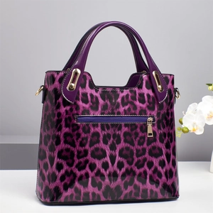 Detail showing shiny purple leopard print crossbody bag with golden metal hardware