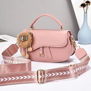 Pink saddle shoulder bag with embroidered wide strap and plush lion charm for women