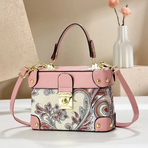 Detail of pink paisley patchwork handbag with golden hardware and leather handle