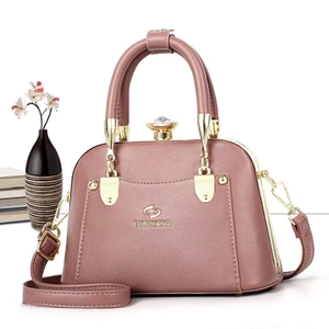 Detail of dusty pink tote bag showing lychee grain leather and crystal gem lock