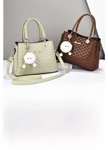 Detail of printed tote bags with plush monster charms and removable shoulder straps