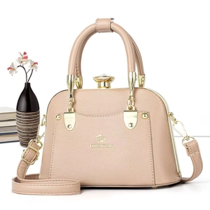 Detailed shot of beige pebbled leather tote with golden twist lock and logo