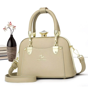 Detail of light beige tote bag featuring a crystal knob closure and elegant top handle