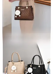 Close-up of stylish handbags with letter print, round metal handles and plush charms