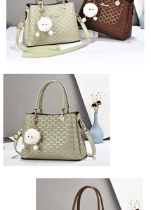 Detail of light green leather handbag with embossed letters and plush ball charm
