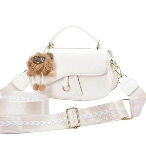 White saddle shoulder bag with embroidered strap and brown lion plush pendant charm