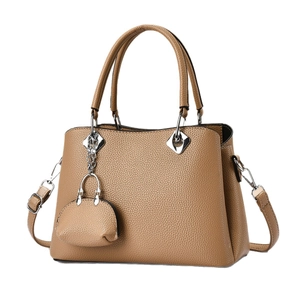 Large caramel litchi leather tote bag with adjustable shoulder strap and mini charm