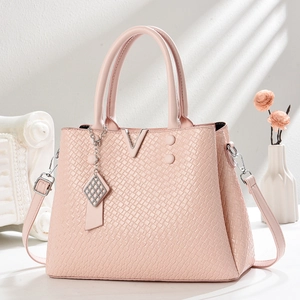 Sac fourre-tout rose gaufré croco avec détail V doré et bandoulière sur fond élégant