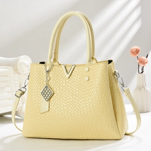 Sac à main jaune crème avec motif crocodile et boucle en V sur fond blanc minimaliste