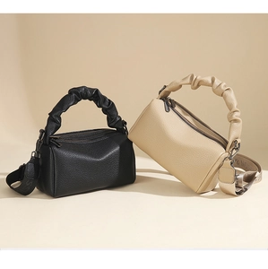 Detail of lychee pattern leather bags with ruffled handles and canvas shoulder straps